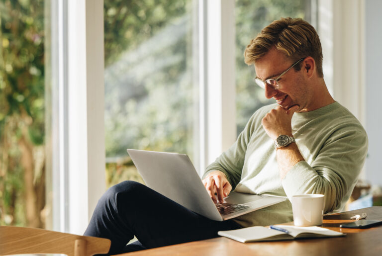 Person sat down reading text on a laptop